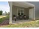 Relaxing covered back porch with three chairs and access to a well-maintained yard at 325 Cornwall Dr, Salisbury, NC 28147