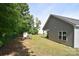 The backyard shows the vinyl siding of the house with a large grassy area and play area at 325 Cornwall Dr, Salisbury, NC 28147