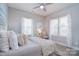 Comfortable bedroom with neutral tones, wood-look flooring, and natural light from two windows at 325 Cornwall Dr, Salisbury, NC 28147