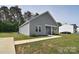 A well-maintained single-story home with a concrete walkway, front yard, and gray vinyl siding at 325 Cornwall Dr, Salisbury, NC 28147