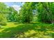 Expansive backyard featuring lush green grass and mature trees creating a serene setting at 3387 Passmore Rd, Rock Hill, SC 29730