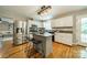 Modern kitchen featuring stainless steel appliances, granite countertops, island with seating, and hardwood floors at 3387 Passmore Rd, Rock Hill, SC 29730
