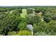 Aerial shot of a home nestled in a lush, green landscape, near a golf course and a tranquil lake at 3932 Rounding Run Rd, Charlotte, NC 28277
