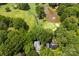Aerial view of a home in a wooded neighborhood, near a golf course and water feature at 3932 Rounding Run Rd, Charlotte, NC 28277