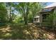 Grassy backyard with mature trees and a charming screened-in porch at 3932 Rounding Run Rd, Charlotte, NC 28277