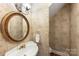 Elegant powder room with pedestal sink, decorative mirror, and custom wallpaper at 3932 Rounding Run Rd, Charlotte, NC 28277