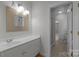 This bathroom features a single sink vanity, decorative mirror and tiled floors at 3932 Rounding Run Rd, Charlotte, NC 28277