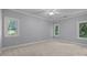 Neutral bedroom featuring soft carpet and large windows letting in plenty of natural light at 3932 Rounding Run Rd, Charlotte, NC 28277