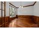 Bright, airy dining area featuring elegant wood trim, hardwood floors, and a large window overlooking greenery at 3932 Rounding Run Rd, Charlotte, NC 28277