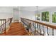 Second floor foyer with hardwood floors and a decorative railing overlooking the front entry at 3932 Rounding Run Rd, Charlotte, NC 28277