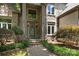 Detailed view of a stone house entrance, accentuated by manicured landscaping and a stylish front door at 3932 Rounding Run Rd, Charlotte, NC 28277