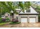 Stunning stone and shingle home with a two-car garage, complemented by lush landscaping and mature trees at 3932 Rounding Run Rd, Charlotte, NC 28277