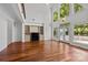 Sun-drenched living area with hardwood floors, a fireplace, and large windows offering views of the outdoor landscape at 3932 Rounding Run Rd, Charlotte, NC 28277