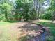 Backyard firepit area with wood surround and tall trees at 40278 Nc 740 Hwy, New London, NC 28127