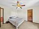 Bedroom featuring plush carpet, a ceiling fan, and natural wood trim around a matching door at 40278 Nc 740 Hwy, New London, NC 28127