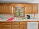 Kitchen counter area features window view, oak cabinets and a white dishwasher at 40278 Nc 740 Hwy, New London, NC 28127