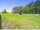 View of an outbuilding with picnic table in a grassy and fenced field at 40278 Nc 740 Hwy, New London, NC 28127