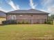 Backyard with black metal fencing, lush green grass, and AC unit at 405 Newstyle Way, Gastonia, NC 28056