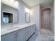 Bright bathroom featuring double sinks, white cabinetry, and a large walk-in shower with tiled walls at 405 Newstyle Way, Gastonia, NC 28056