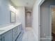 Bright bathroom featuring double sinks, white cabinetry, and a large walk-in shower with tiled walls at 405 Newstyle Way, Gastonia, NC 28056