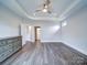 Bedroom with hardwood floors, ceiling fan, and open doorway leading to bathroom at 405 Newstyle Way, Gastonia, NC 28056