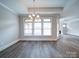 Dining room with a modern chandelier, large windows, and hardwood flooring at 405 Newstyle Way, Gastonia, NC 28056