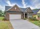 Charming single Gathering home features brick facade, manicured landscaping, and two-car garage at 405 Newstyle Way, Gastonia, NC 28056