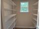 Bright walk-in closet with window and white wire shelving for optimized organization at 415 Dogwood Ln, Statesville, NC 28625