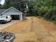 View of the home's driveway and garage, with the yard newly mulched with straw at 415 Dogwood Ln, Statesville, NC 28625