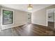A bright bedroom features wood-look flooring and natural light from two windows at 5001 Grand Canyon Nw Rd, Concord, NC 28027