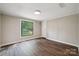 Well-lit bedroom featuring stylish wood-look flooring and a sunny window at 5001 Grand Canyon Nw Rd, Concord, NC 28027