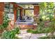 Relaxing covered porch with comfortable outdoor seating, potted plants, and a brick facade at 510 Wiley Ave, Salisbury, NC 28144