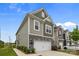 Stylish townhouse with a two-car garage and stone accents, showcasing modern curb appeal at 5207 Maynard Hill Dr, Monroe, NC 28110