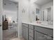 Bathroom featuring a double vanity, large mirror, and open view to the living room beyond at 5581 Soft Shell Dr, Lancaster, SC 29720
