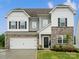 Charming two-story home featuring a stone facade, black shutters, and a manicured lawn at 5581 Soft Shell Dr, Lancaster, SC 29720