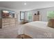 Spacious main bedroom featuring neutral tones, dual windows, and a dresser with a large television at 5581 Soft Shell Dr, Lancaster, SC 29720