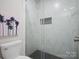 Modern shower with elegant marble tiling, a built-in niche, and contrasting black floor tiles at 5581 Soft Shell Dr, Lancaster, SC 29720