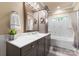 Well-lit bathroom with granite vanity, decorative mirror, and shower with tub at 6010 Albiza Dr, Harrisburg, NC 28075