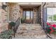 Inviting entrance with stone steps, a decorative door, and beautiful landscaping at 6010 Albiza Dr, Harrisburg, NC 28075