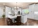 Kitchen offers white cabinetry, stainless appliances, an island with seating and modern pendant lighting at 6010 Albiza Dr, Harrisburg, NC 28075