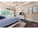 Main bedroom featuring tray ceiling, dresser, windows, decor, and hardwood floors at 6010 Albiza Dr, Harrisburg, NC 28075