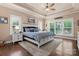 Comfortable main bedroom with tray ceiling, fan, windows, and a plush rug at 6010 Albiza Dr, Harrisburg, NC 28075