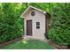 This storage shed is surrounded by trees and shrubbery at 6010 Albiza Dr, Harrisburg, NC 28075