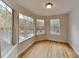 Bright room with hardwood floors and multiple windows offering serene views of the surrounding trees at 6020 Gray Gate Ln # I, Charlotte, NC 28210