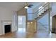 Open-concept living room features hardwood floors, a fireplace, and a grand staircase with large windows at 6020 Gray Gate Ln # I, Charlotte, NC 28210