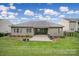 Back exterior featuring a covered patio, green lawn, and well-maintained landscaping at 6021 Piscataway Ct, Rock Hill, SC 29732