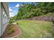 A vast backyard with retaining wall and lush greenery offers a serene outdoor space at 6021 Piscataway Ct, Rock Hill, SC 29732