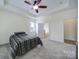 Bedroom features a tray ceiling, a ceiling fan, and plush neutral carpeting at 6021 Piscataway Ct, Rock Hill, SC 29732