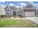 Charming home with stone accents, bay window, manicured lawn, and attached garage at 6021 Piscataway Ct, Rock Hill, SC 29732