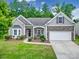 Charming single-Gathering home featuring stone accents, a well-manicured lawn, and an attached two-car garage at 6021 Piscataway Ct, Rock Hill, SC 29732